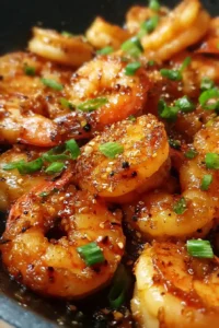 raw shrimp coated for crispy honey garlic shrimp beside whisked eggs, breadcrumbs, and seasoning ingredients on marble surface
