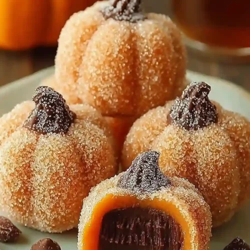 Sugar-coated pumpkin-shaped truffles filled with rich chocolate ganache on a plate