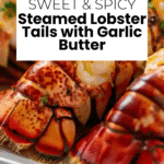 Close-up of garlic butter lobster tails garnished with parsley and lemon wedges on a white plate