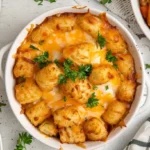 Overhead view of golden cheesy tater tot casserole baked to perfection, topped with melted cheese and parsley.