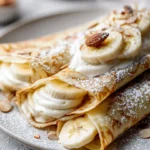 Delicious creamy banana crepes ready to serve on a plate