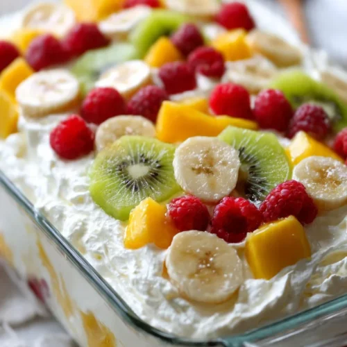 Creamy fruit dessert salad with mixed fruits and a creamy dressing.