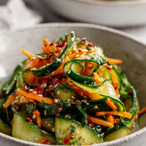 Fresh Cucumber Carrot Salad garnished with herbs in a bowl