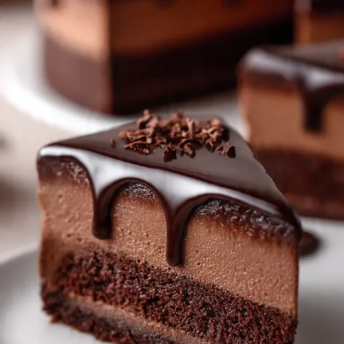 Delicious dark chocolate mousse cake topped with chocolate shavings and berries