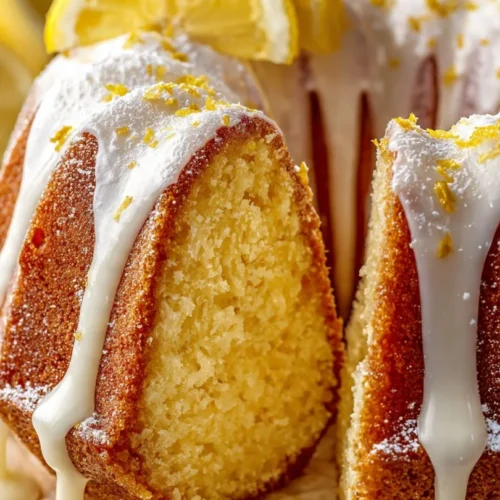 Delicious lemon cake topped with fresh lemon zest and icing on a plate