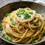Plate of Mom's Crazy-Good Garlic Noodles garnished with herbs