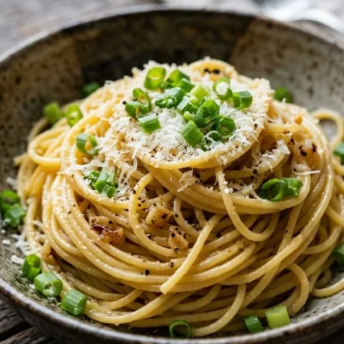 Plate of Mom's Crazy-Good Garlic Noodles garnished with herbs