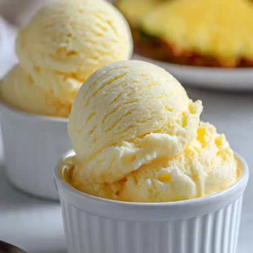 Delicious bowl of homemade pineapple ice cream topped with fresh pineapple slices