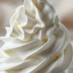 Bowl of stabilized whipped cream frosting ready for decorating desserts