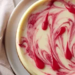 Slice of white chocolate raspberry cheesecake with berries on top