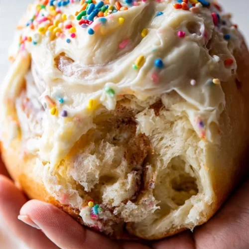Delicious birthday cake cinnamon rolls topped with sprinkles and frosting.