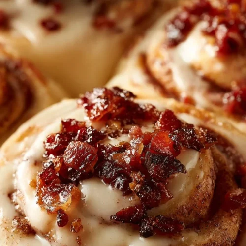 Bourbon Maple Bacon Cinnamon Rolls drizzled with maple syrup and sprinkled with bacon bits.