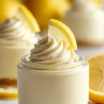Delicious bright lemon mousse dessert topped with lemon zest and mint leaves.
