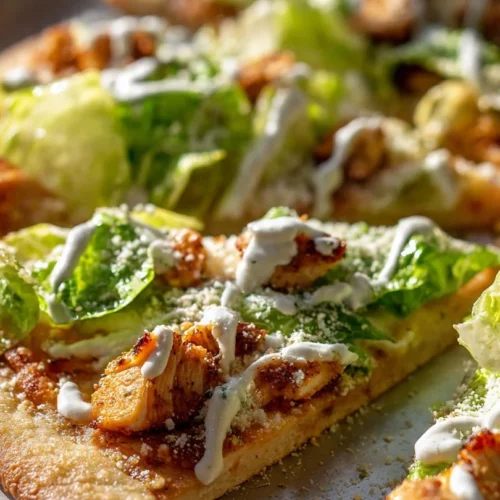 Delicious Chicken Caesar Salad Pizza topped with romaine and creamy dressing