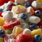 Creamy fruit salad with a variety of colorful fruits in a bowl