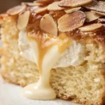 A beautifully presented bee sting cake topped with almonds and whipped cream.