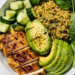 Grilled Chicken Orzo Salad with Avocado on a plate, garnished with herbs
