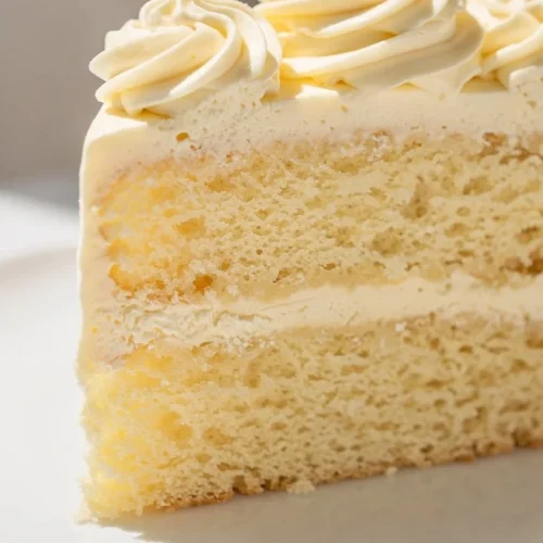 Homemade buttermilk cake with creamy buttercream frosting on a plate