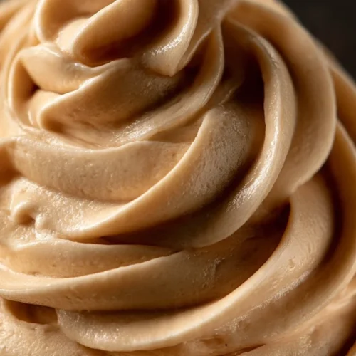 Delicious honey frosting spread on a vanilla cupcake