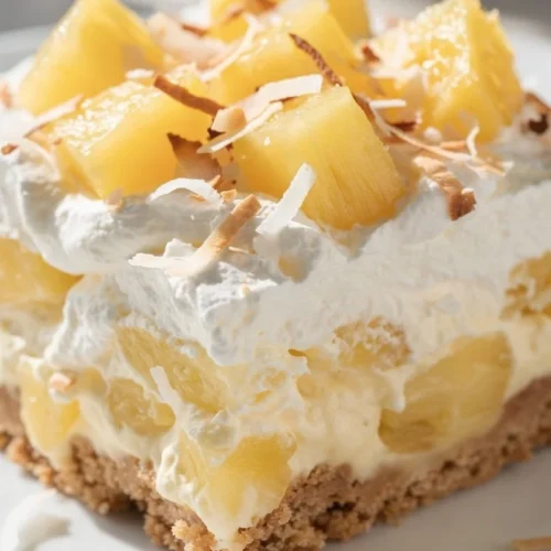 No bake pineapple cream dessert served in a glass dish with tropical garnishes