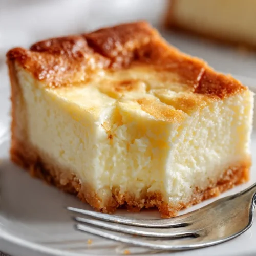 Delicious ooey gooey butter cake with a creamy texture and golden edges.