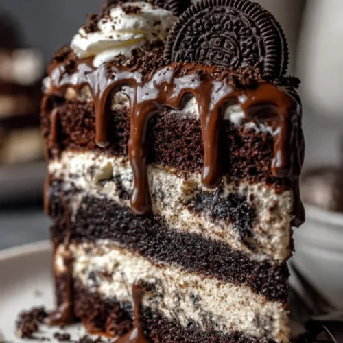 Delicious Oreo Poke Cake topped with crushed Oreo cookies and whipped cream