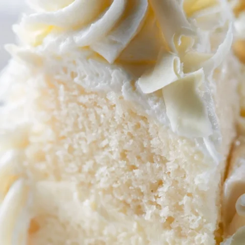 Delicious Pineapple Sunshine Cake topped with fresh pineapple slices and whipped cream.