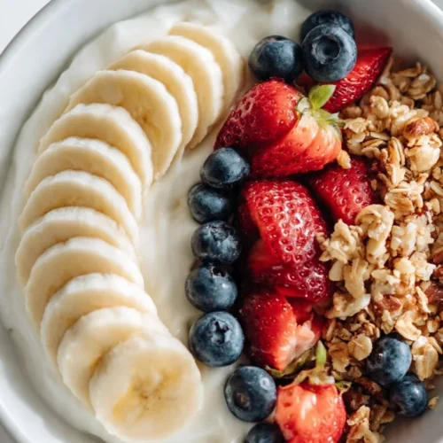 A colorful yogurt bowl topped with fruits, nuts, and granola for a healthy breakfast