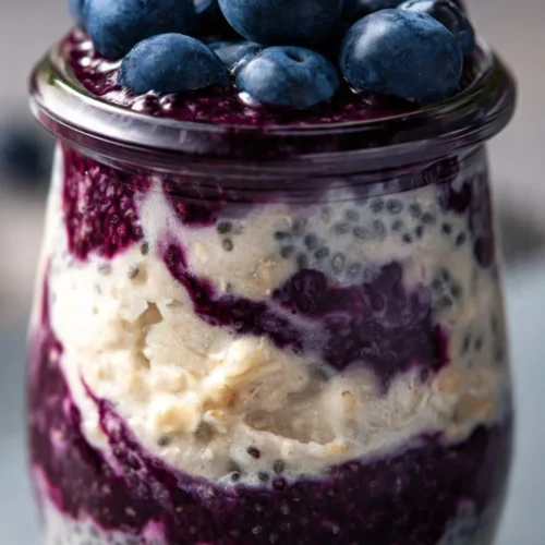 Bowl of blueberry overnight oats topped with fresh blueberries and almonds