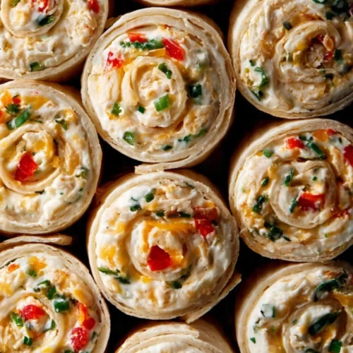 Delicious chicken enchilada tortilla roll ups on a plate, garnished with cilantro.