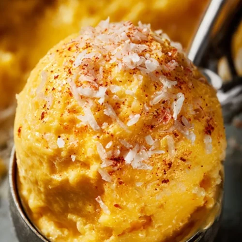 Chili Lime Mango Sorbet served in a bowl with fresh mango slices.