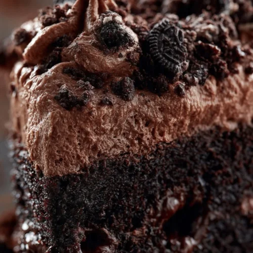 Deliciously layered Dirt Cake topped with gummy worms and crushed Oreos.
