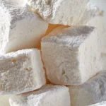 Homemade honey marshmallows displayed on a plate with a drizzle of honey