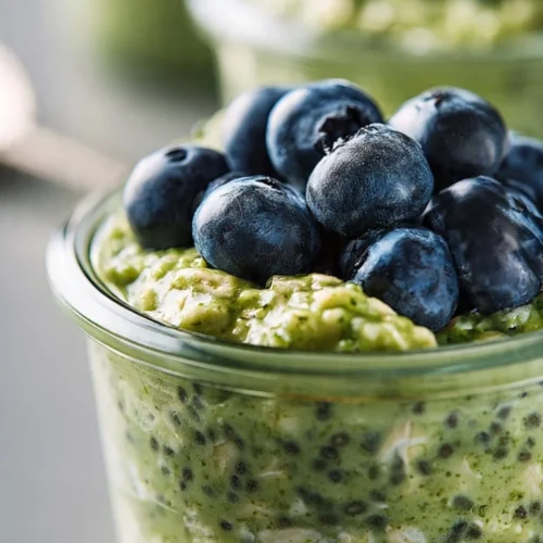 Healthy matcha overnight oats topped with fruits and nuts in a jar