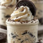 Oreo no-bake cheesecake cups topped with crushed Oreos and whipped cream