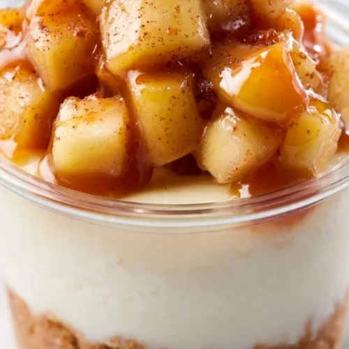Salted caramel apple dessert cups topped with whipped cream and caramel drizzle