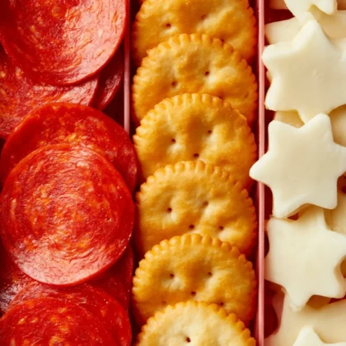 Homemade DIY pizza crackers lunchable with cheese, pepperoni, and toppings.