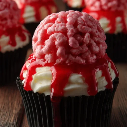 Halloween brain cupcakes decorated with eerie red icing and gummy worms