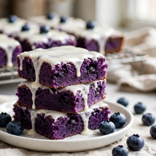 Delicious glazed blueberry brownies topped with a sweet glaze and fresh blueberries.